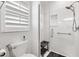 Modern bathroom featuring glass door shower, rainfall shower head, new toilet and shuttered window at 2015 Palo Alto Ave, The Villages, FL 32159