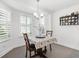 Bright breakfast nook featuring a modern chandelier, decorative teacup display and a sunlit window with wooden shutters at 2015 Palo Alto Ave, The Villages, FL 32159