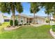 A lovely home showcasing a well-kept lawn, lush trees, and a charming front patio area at 2015 Palo Alto Ave, The Villages, FL 32159