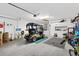 Spacious garage with ample storage, featuring a golf cart, workspace, and various equipment for hobbies and projects at 2015 Palo Alto Ave, The Villages, FL 32159
