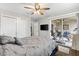 Comfortable bedroom featuring a ceiling fan, closet, and access to a screened patio, creating a relaxing retreat at 2015 Palo Alto Ave, The Villages, FL 32159