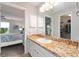 Bright bathroom featuring a granite countertop and a view into the primary bedroom at 2022 Claudio Ln, The Villages, FL 32159