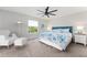 Bright bedroom featuring a coastal-themed bedspread, a modern ceiling fan, and comfortable seating at 2022 Claudio Ln, The Villages, FL 32159