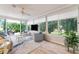 Bright enclosed lanai with floor-to-ceiling windows offering serene views of the landscaped outdoors at 2022 Claudio Ln, The Villages, FL 32159