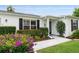 Inviting front entrance with well-maintained landscaping, a decorative shrub, and a tiled walkway leading to the front door at 2022 Claudio Ln, The Villages, FL 32159