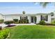 Charming single-story home featuring a manicured lawn and mature landscaping at 2022 Claudio Ln, The Villages, FL 32159