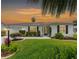 Charming single-story home features a manicured lawn, mature landscaping, and a concrete driveway with a unique design at sunset at 2022 Claudio Ln, The Villages, FL 32159