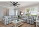 Bright living room featuring coordinated seating, a ceiling fan, and natural light streaming through the windows at 2022 Claudio Ln, The Villages, FL 32159