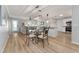 Open floorplan view of dining and living rooms with abundant light and wood flooring at 2022 Claudio Ln, The Villages, FL 32159