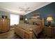 Inviting bedroom with dark blue accent wall, wooden furniture and ceiling fan at 2039 Thurmond Ave, The Villages, FL 32162