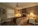 Cozy bedroom with a comfortable bed, ceiling fan, and bedside lamps at 2039 Thurmond Ave, The Villages, FL 32162