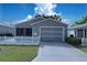 Inviting single-story home with a well-maintained lawn and a convenient attached garage at 2039 Thurmond Ave, The Villages, FL 32162