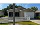 Charming single-story home features a white picket fence, lush lawn, and attached garage at 2039 Thurmond Ave, The Villages, FL 32162