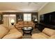 Inviting living room features neutral color palette, comfortable leather furniture and modern entertainment center at 2039 Thurmond Ave, The Villages, FL 32162