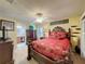 Elegant bedroom features decorative bedding, a ceiling fan, a dresser, and a view into the bathroom at 2131 Burley Ave, Clermont, FL 34711