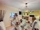 Dining room featuring a glass table with seating, a unique chandelier, and views into the living area at 2131 Burley Ave, Clermont, FL 34711