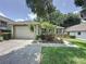 Charming single-story home featuring a well-manicured lawn, lush landscaping, and an attached two-car garage at 2131 Burley Ave, Clermont, FL 34711