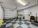Spacious garage with diamond-patterned floor, storage, and white painted walls at 2131 Burley Ave, Clermont, FL 34711