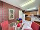 View of kitchen with adjacent dining area, featuring plaid wallpaper and white appliances at 2131 Burley Ave, Clermont, FL 34711