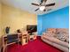 This living room features bright yellow and blue walls, a ceiling fan, and a comfortable sofa at 2131 Burley Ave, Clermont, FL 34711