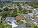 Aerial view of a property with a manicured lawn, a house with a brown roof, and a long driveway at 22217 Caledonia Dr, Leesburg, FL 34748