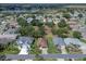 Expansive aerial view of a charming community with lush greenery and a tranquil lake at 22217 Caledonia Dr, Leesburg, FL 34748