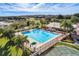 Aerial view of the community pool, tennis court, and surrounding lush landscape and golf course at 22217 Caledonia Dr, Leesburg, FL 34748