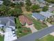 Aerial view of a well-maintained property featuring a manicured lawn, garden beds, and a paved driveway at 22217 Caledonia Dr, Leesburg, FL 34748