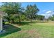 Spacious, grassy backyard with mature trees, adjacent to neighboring properties, offering privacy and shade at 22217 Caledonia Dr, Leesburg, FL 34748