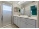Bathroom featuring double vanity sinks, a glass-enclosed shower and neutral tones at 22217 Caledonia Dr, Leesburg, FL 34748
