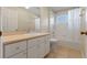 Well-lit bathroom featuring a vanity with ample storage and a shower-tub combination with a white curtain at 22217 Caledonia Dr, Leesburg, FL 34748