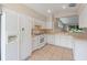 Bright kitchen features white appliances, ample cabinet space, and a tile floor at 22217 Caledonia Dr, Leesburg, FL 34748