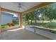 Enclosed lanai with a ceiling fan offering views of the well-maintained garden and lawn at 22217 Caledonia Dr, Leesburg, FL 34748
