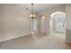 Spacious living room featuring neutral walls, carpeting, arched doorways and ample natural light at 22217 Caledonia Dr, Leesburg, FL 34748