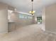 Open-concept living room featuring neutral walls, carpeting, sliding glass doors and a breakfast bar at 22217 Caledonia Dr, Leesburg, FL 34748