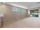 Open living room features neutral walls, carpeting, sliding glass doors, a ceiling fan, and natural light at 22217 Caledonia Dr, Leesburg, FL 34748