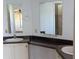 A bathroom featuring a dual sink vanity with dark granite counter tops and large mirrors at 2871 Myakka River Rd, Tavares, FL 32778