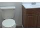 A bathroom featuring a white toilet and vanity with wood-grained cabinets at 2871 Myakka River Rd, Tavares, FL 32778