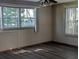 An empty room with dark wood laminate flooring, paneled walls and a ceiling fan and light fixture at 2871 Myakka River Rd, Tavares, FL 32778