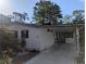 Charming home features a covered carport, a manicured garden, and a clean exterior design at 2871 Myakka River Rd, Tavares, FL 32778
