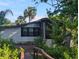 A charming home nestled amongst lush greenery, featuring a screened porch and well-maintained exterior at 2871 Myakka River Rd, Tavares, FL 32778