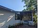 A quaint home showcasing a screened porch and a meticulously maintained exterior with lush landscaping at 2871 Myakka River Rd, Tavares, FL 32778