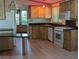 Open kitchen with an island, light wood cabinets and white appliances at 2871 Myakka River Rd, Tavares, FL 32778