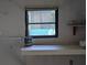 Bright storage area featuring a window, paint can, shelving, and work bench at 2871 Myakka River Rd, Tavares, FL 32778