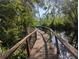 A wooden boardwalk leads to a boat, offering a secluded and peaceful access to the water at 2871 Myakka River Rd, Tavares, FL 32778