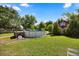 An expansive backyard features a above-ground pool and charming red outbuilding at 28924 Discovery Rd, Tavares, FL 32778