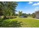 Expansive backyard featuring a pool, lush greenery, mature trees, and a charming red outbuilding at 28924 Discovery Rd, Tavares, FL 32778