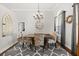 Elegant dining room features a chandelier, large wall clock, floral print chairs, and a decorative window treatment at 28924 Discovery Rd, Tavares, FL 32778
