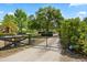Gated driveway entrance with mature trees and landscaping leading to the main home at 28924 Discovery Rd, Tavares, FL 32778