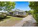 Exterior view of a well-maintained home with a long driveway and lush surrounding trees and landscaping at 28924 Discovery Rd, Tavares, FL 32778